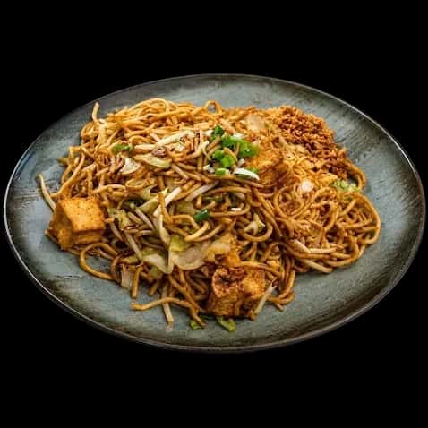 Gebratene Wok-Nudeln mit Gemüse auf einem grauen Teller
