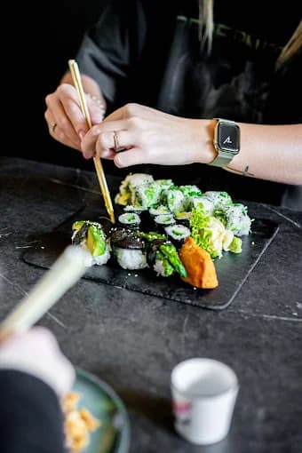 Sushi wird mit Stäbchen genommen