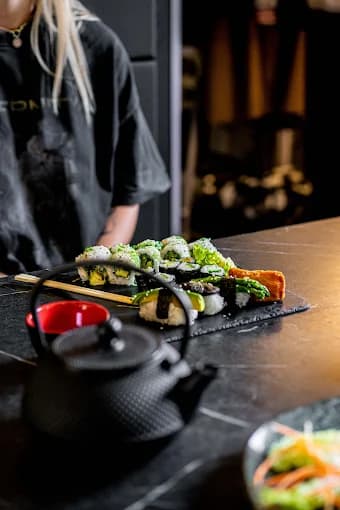 Sushi mit Salat und gusseiserner Teekanne