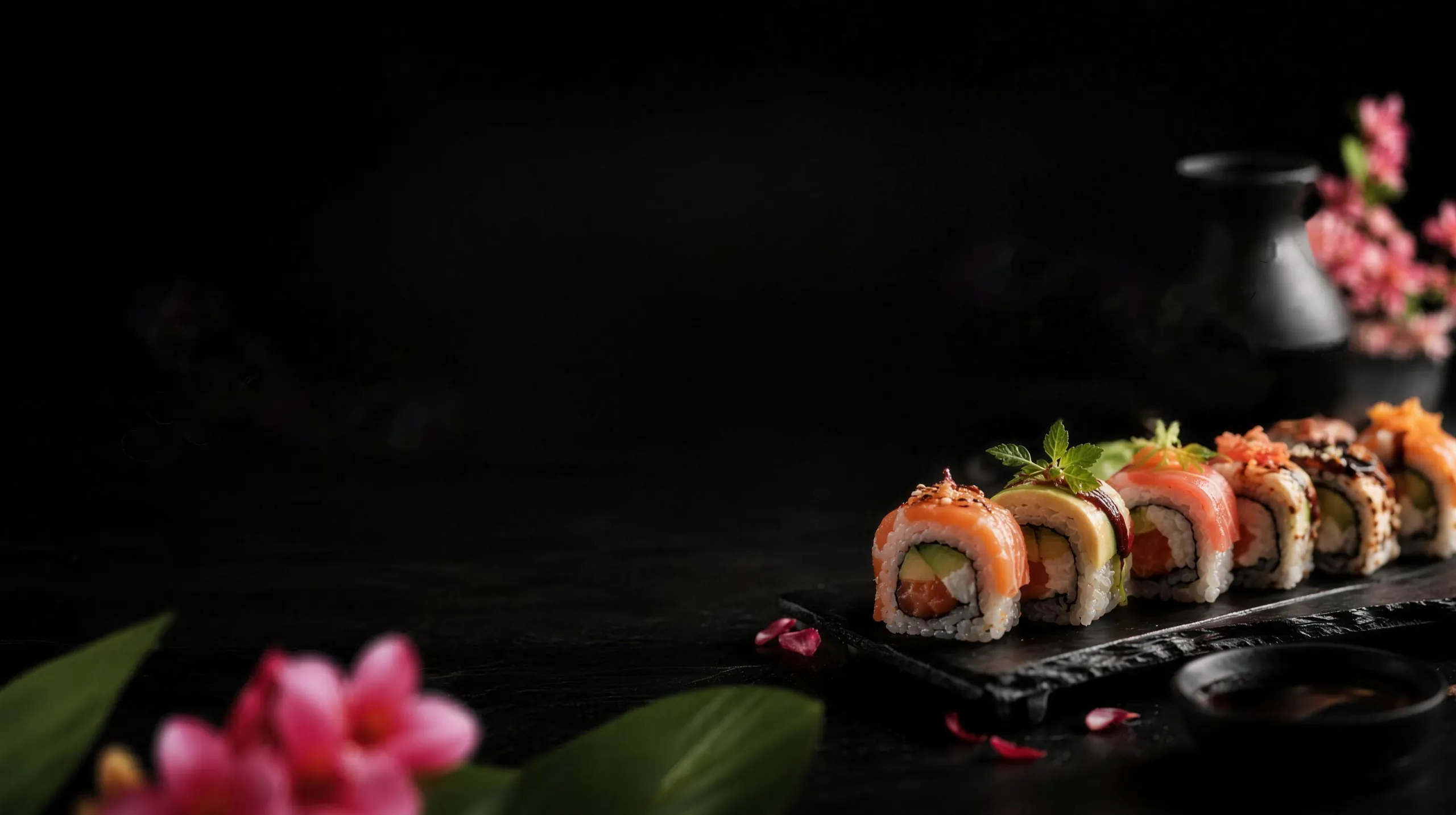 Sushi-Rollen auf schwarzem Schiefer mit Kirschblüten im Lemongrass Aachen