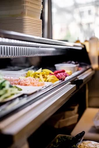 Frisch geschnittene Zutaten in der Kühlvitrine an der Sushi-Theke